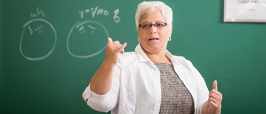 Faculty member teaching students sign language.