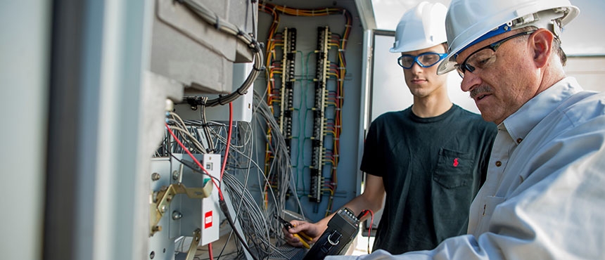 Student working with faculty member at substation.